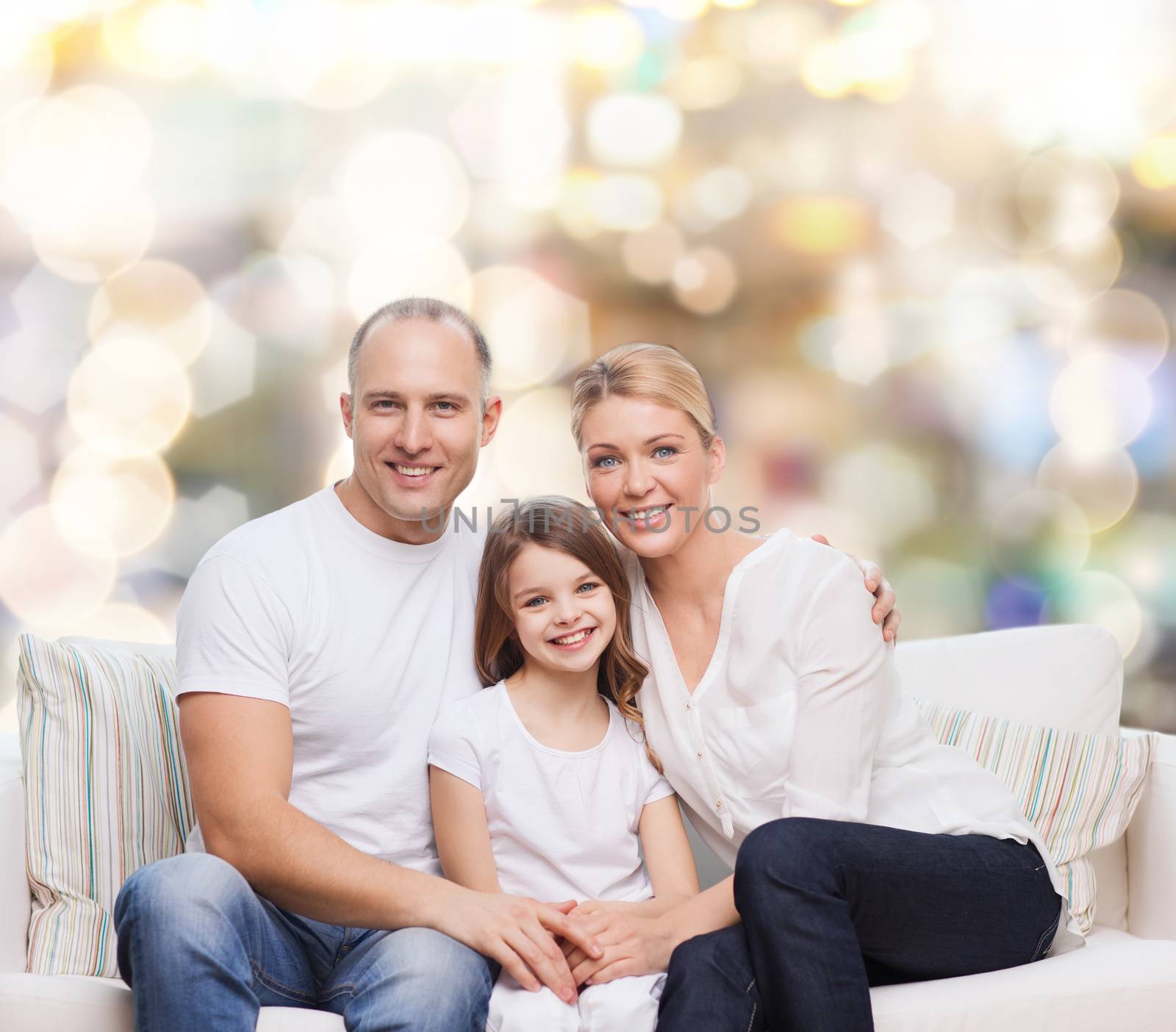 family, childhood, holidays and people concept - smiling mother, father and little girl over lights background