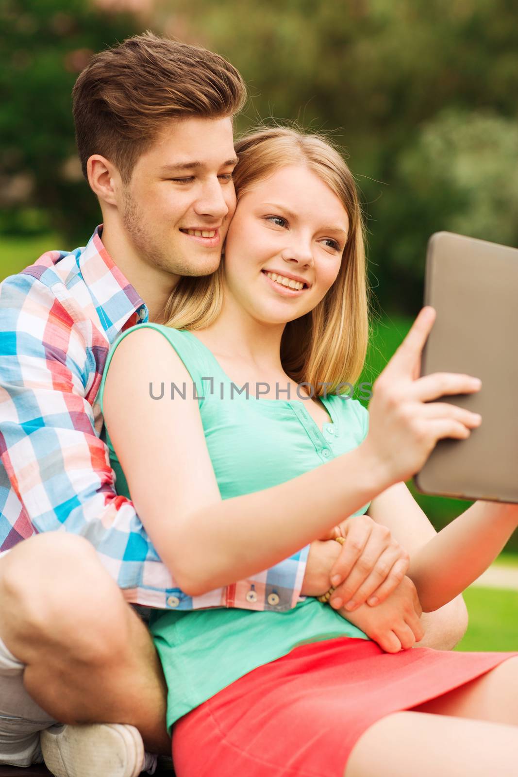 smiling couple with tablet pc making selfie by dolgachov