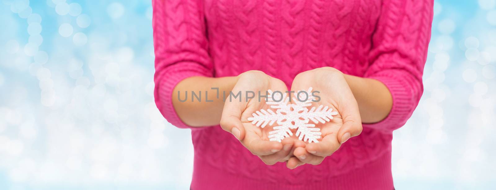 close up of woman in sweater holding snowflake by dolgachov