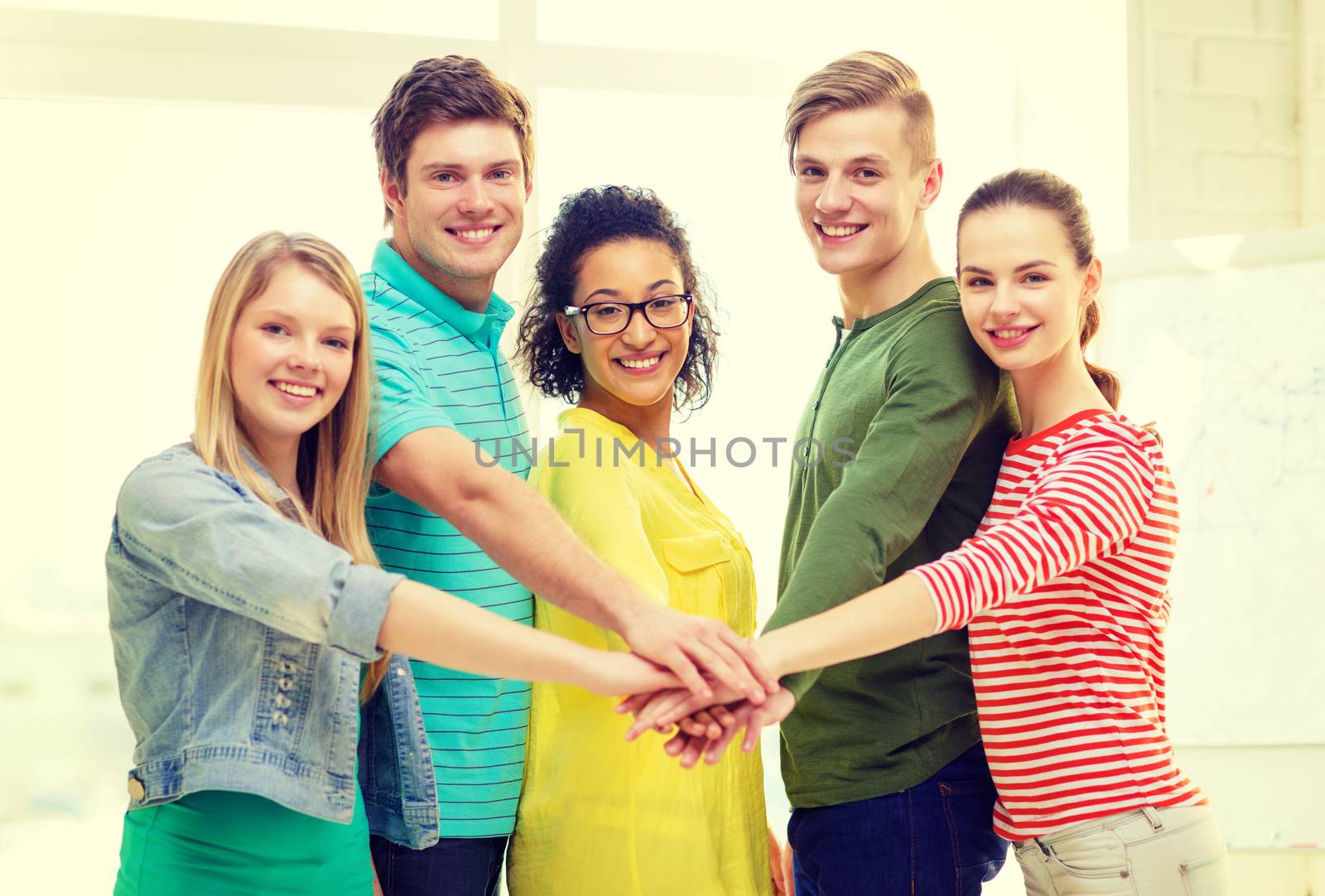 smiling students with hands on top of each other by dolgachov