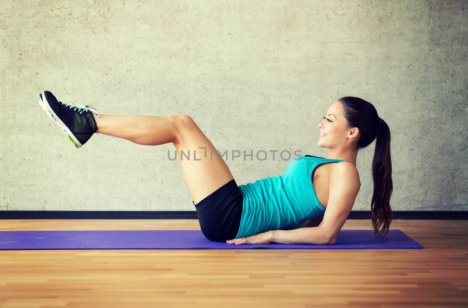 fitness, sport, training and lifestyle concept - smiling woman doing exercises on mat in gym