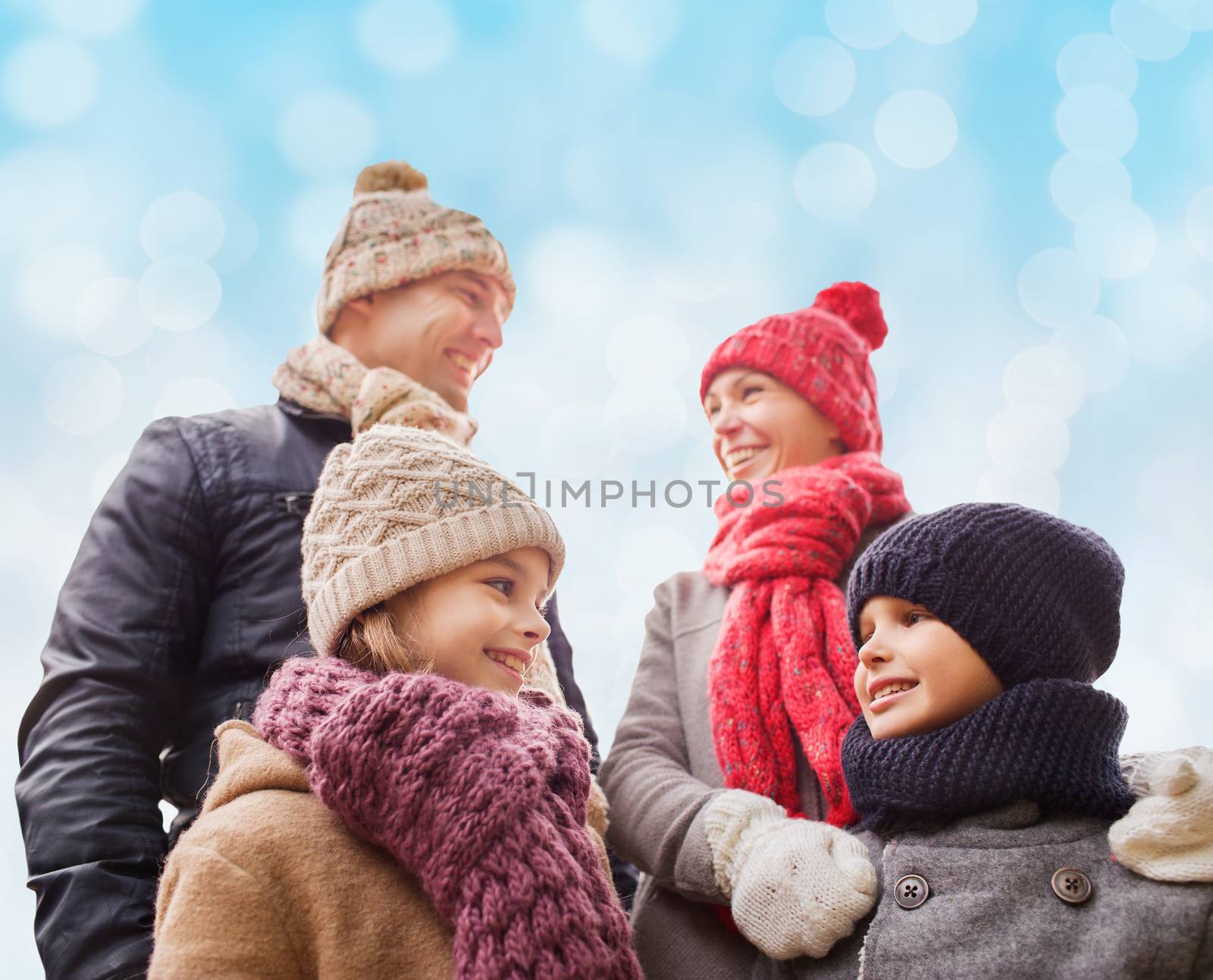 happy family in winter clothes outdoors by dolgachov