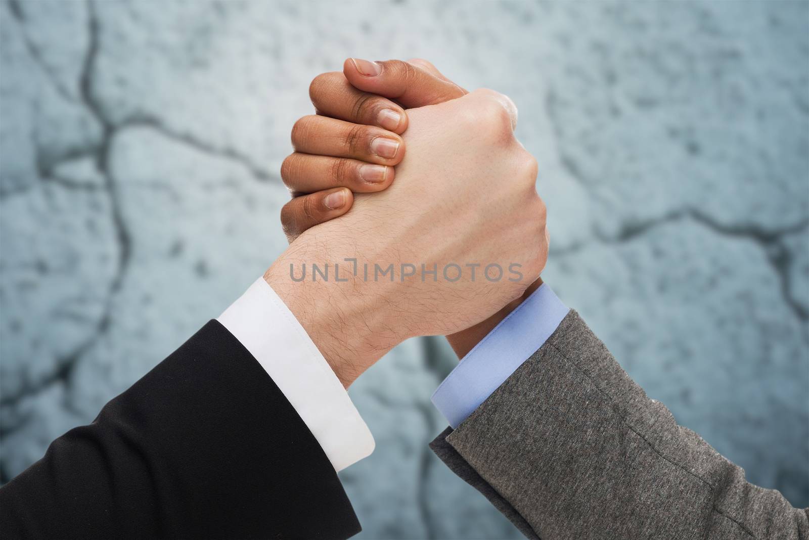 business, people and competition concept - close up of two people hands arm wrestling over concrete wall background