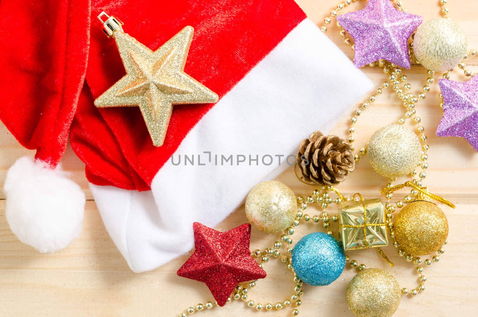 Christmas holiday background with Santa hat and decorations on wooden background.