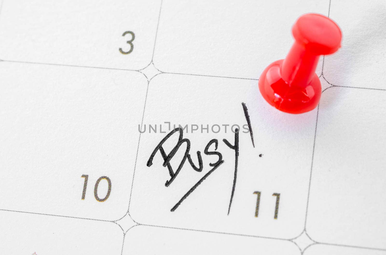 The words Busy written on a white calendar to remind you an important appointment.