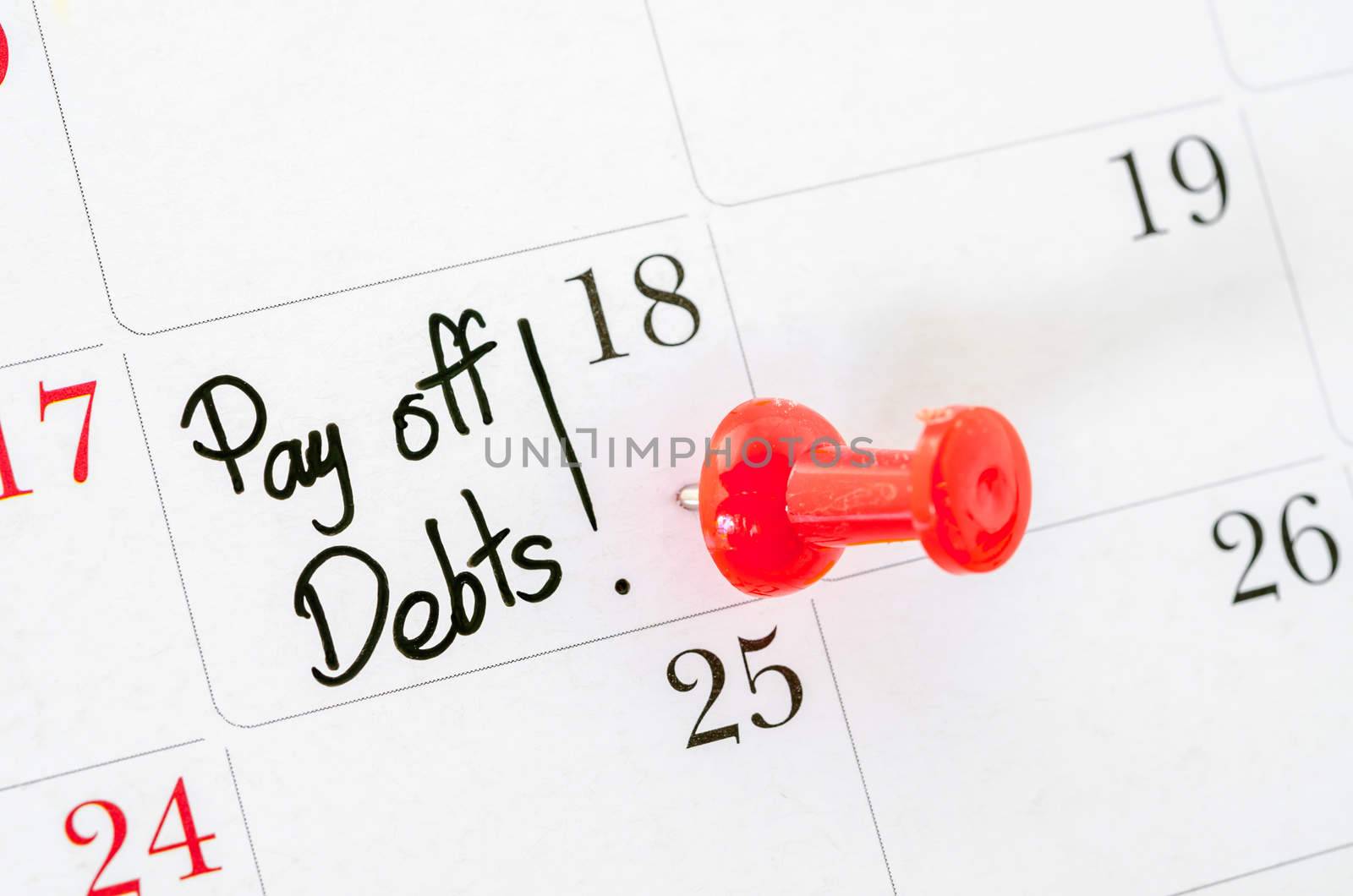 The words Pay off Debts written on a Calendar