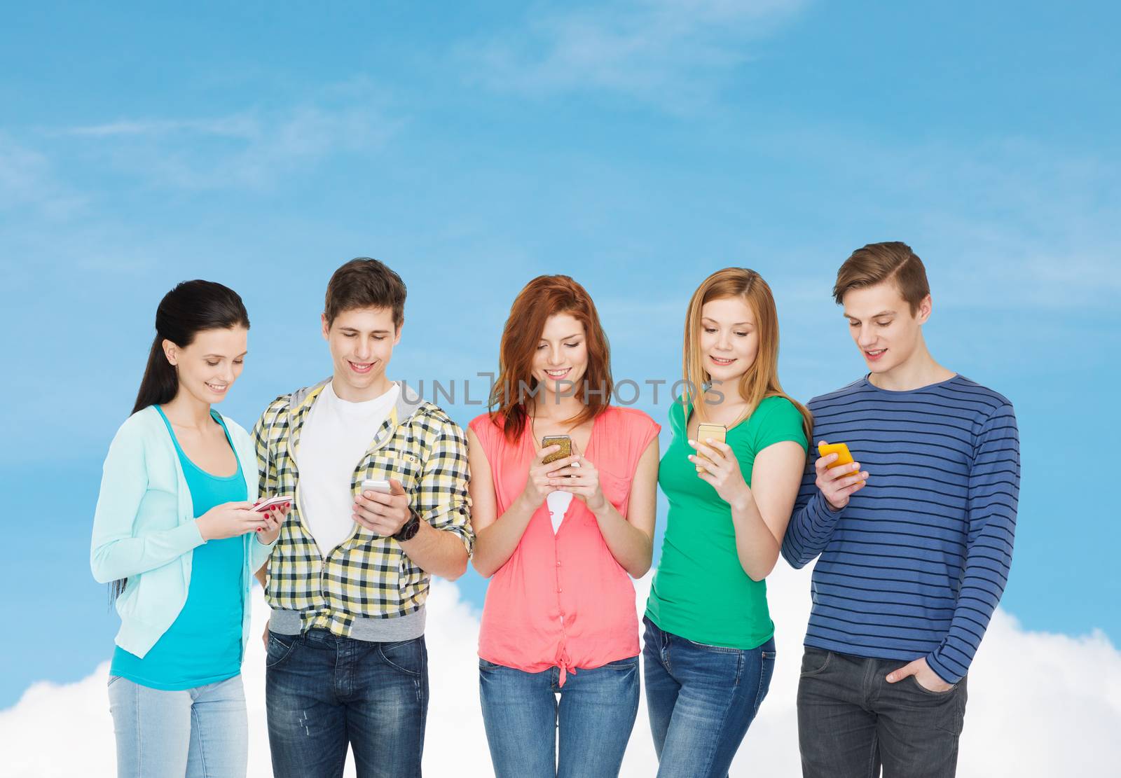 smiling students with smartphones by dolgachov