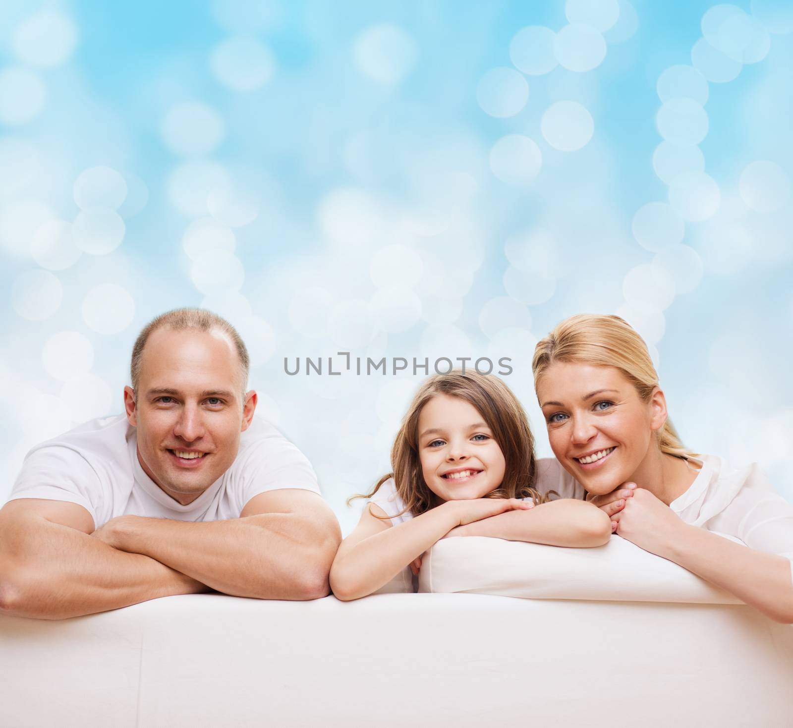 family, childhood, holidays and people - smiling mother, father and little girl over blue lights background