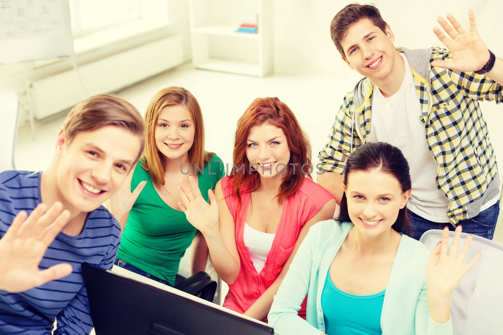 education, technology, school and people concept - group of smiling students waving hands in computer class at school