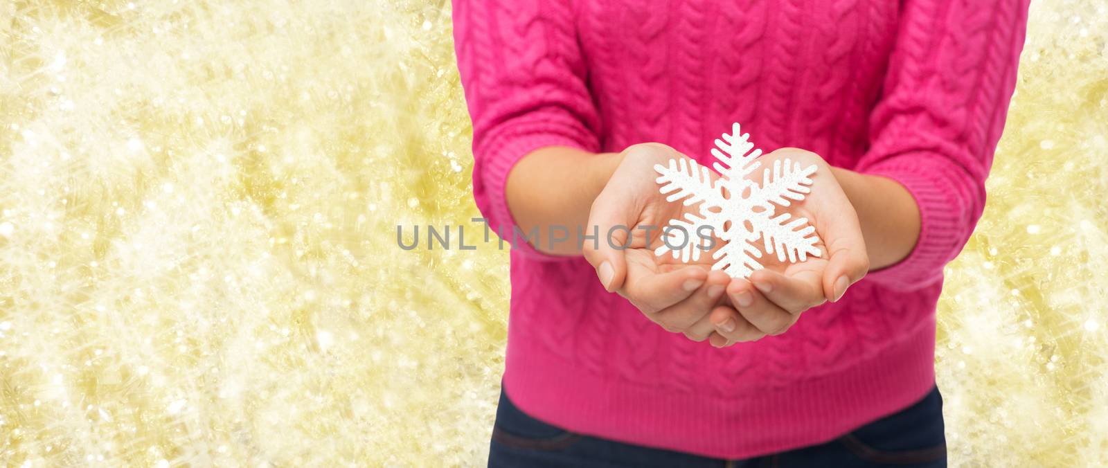 close up of woman holding snowflake decoration by dolgachov