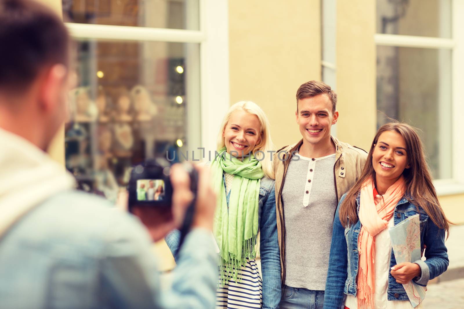 group of smiling friends taking photo outdoors by dolgachov