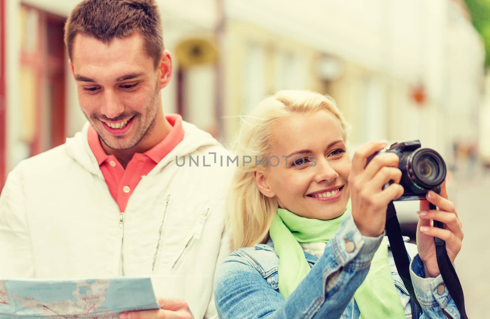 travel, vacation, technology and friendship concept - smiling couple with map and photocamera exploring city