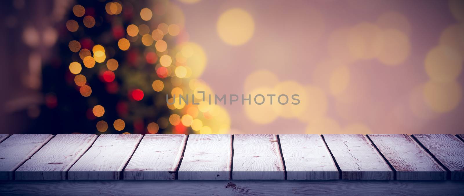 Wooden desk against desk with christmas tree in background