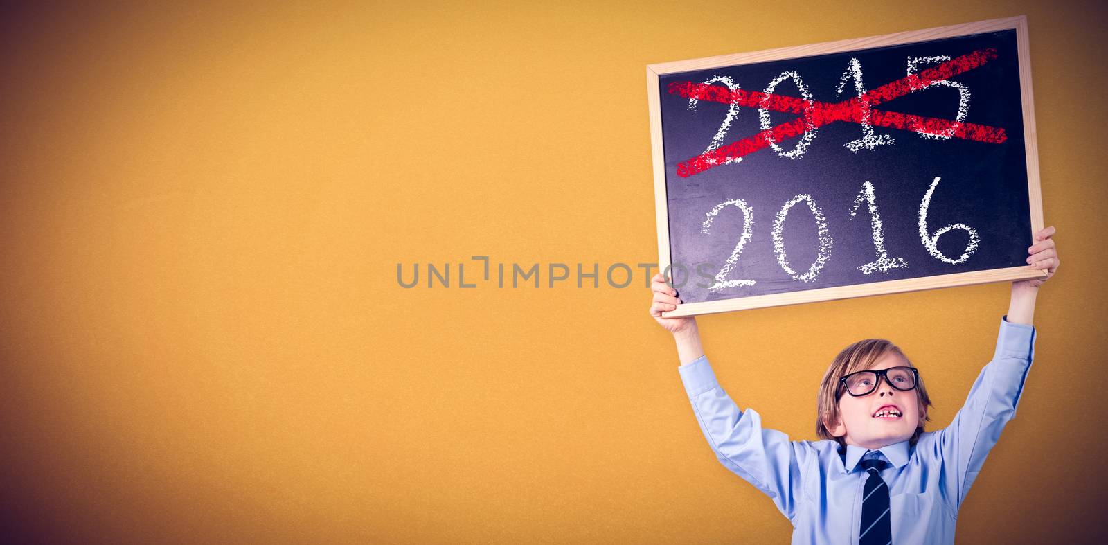 Cute pupil holding chalkboard against orange background