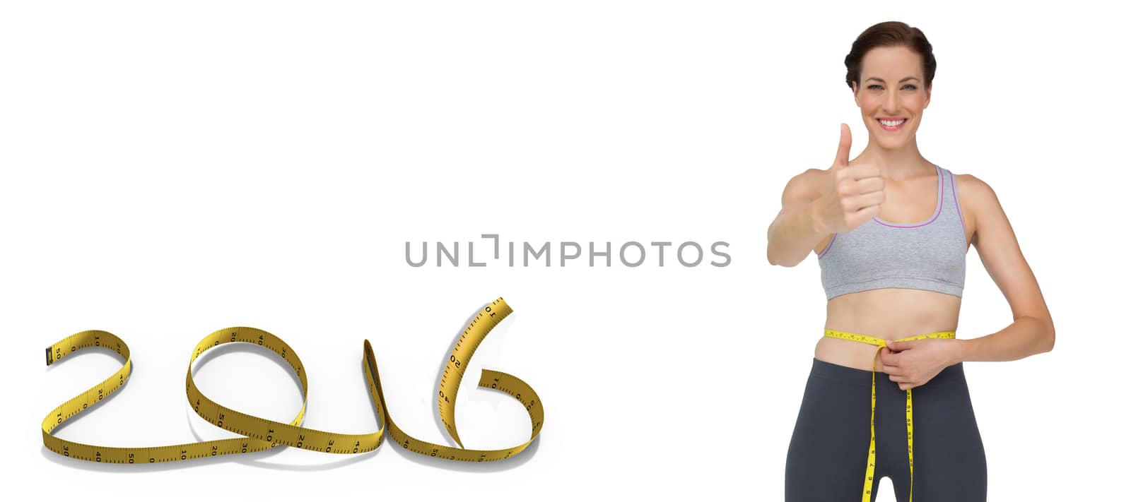 Fit woman measuring waist while gesturing thumbs up against white background with vignette