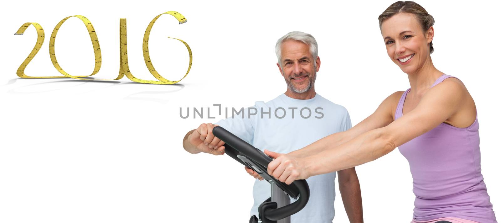 Portrait of a happy woman on stationary bike with trainer against white background with vignette