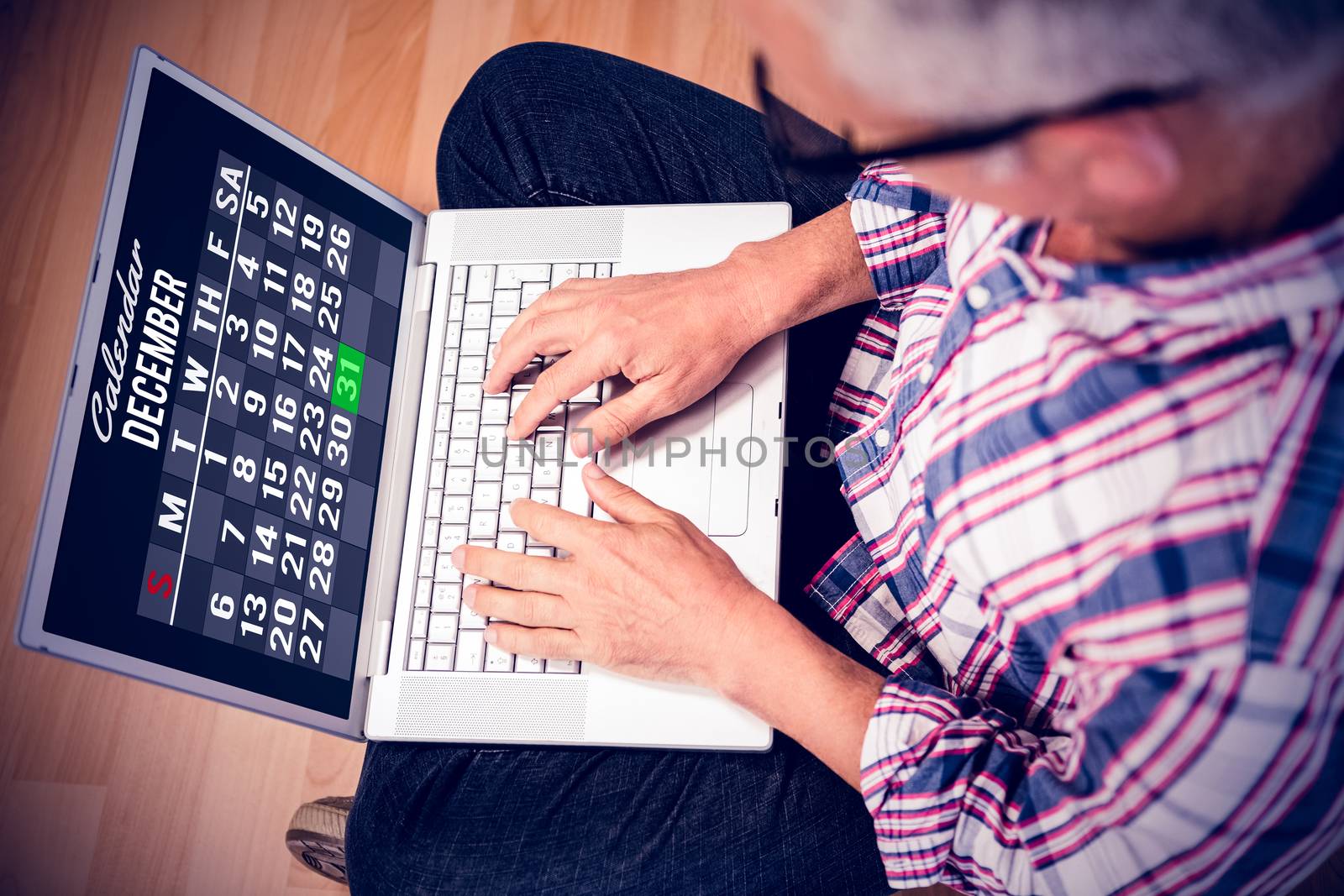 Technology lock screen against man using laptop while sitting on floor at home