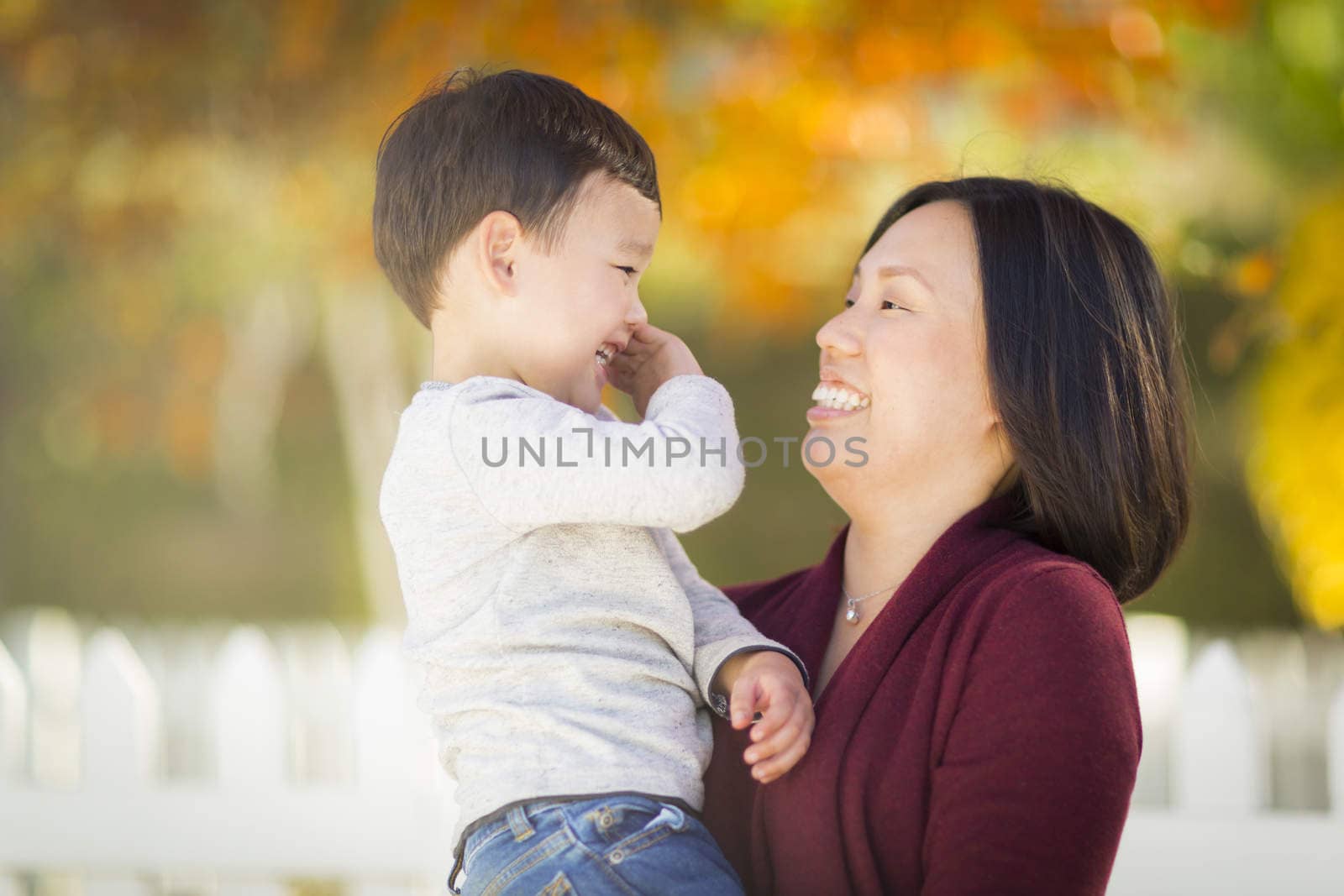 Happy Chinese Mom Having Fun and Holding Her Mixed Race Little Boy.