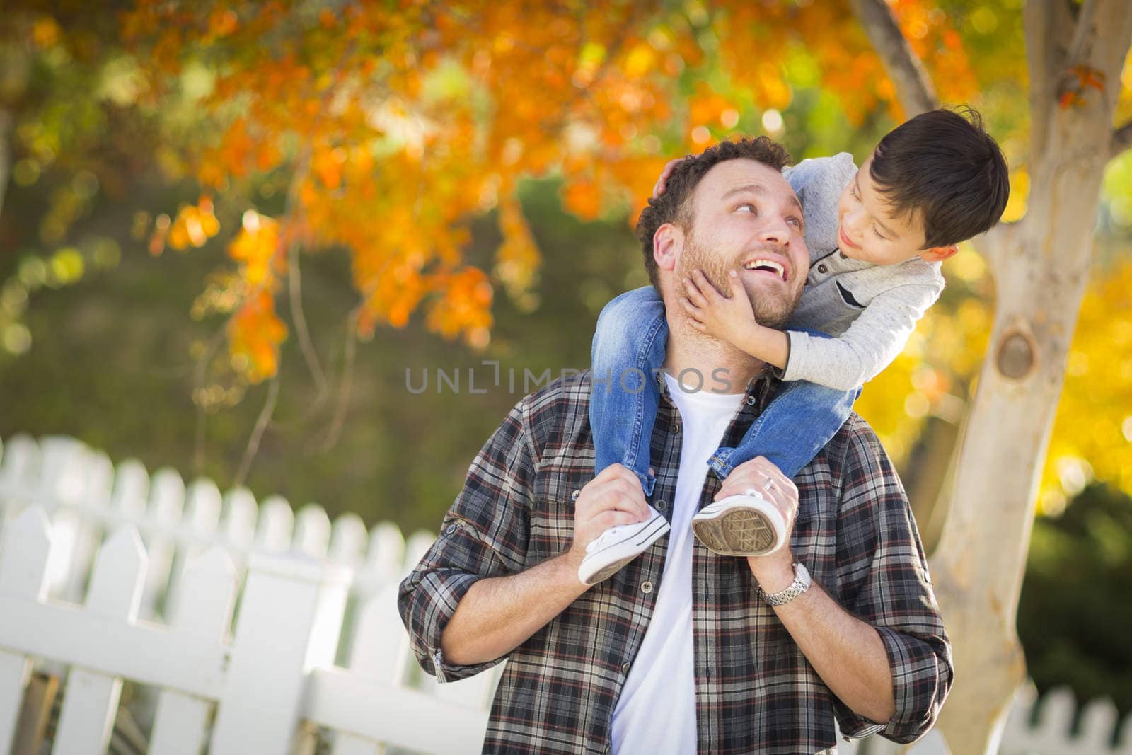 Mixed Race Boy Riding Piggyback on Shoulders of Caucasian Father by Feverpitched