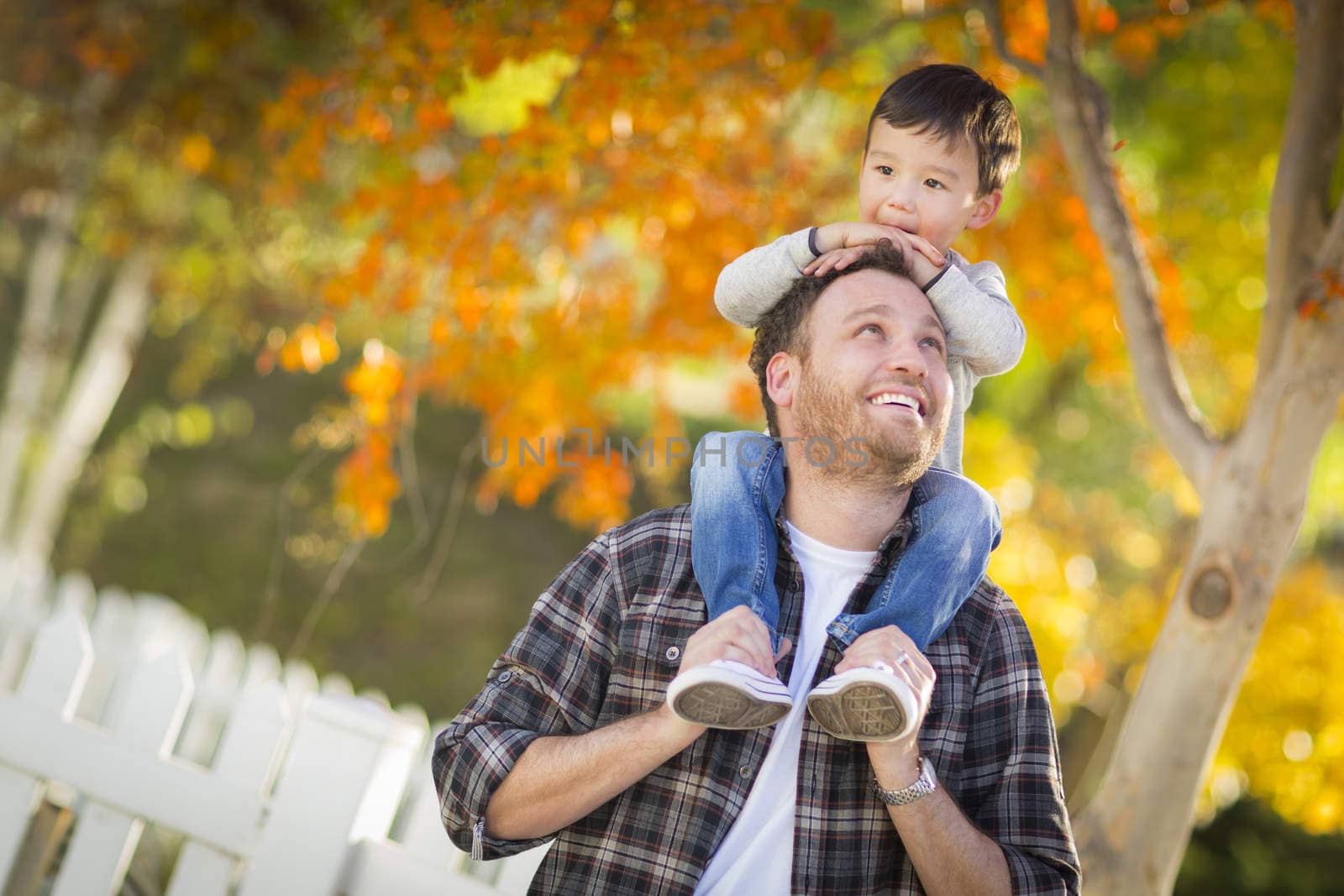 Mixed Race Boy Riding Piggyback on Shoulders of Caucasian Father by Feverpitched