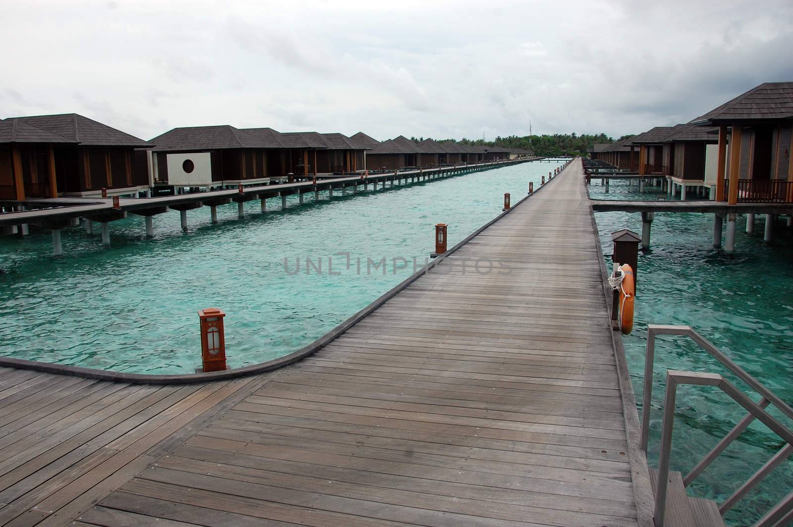 Timber pier and bungalow at Maldives by danemo