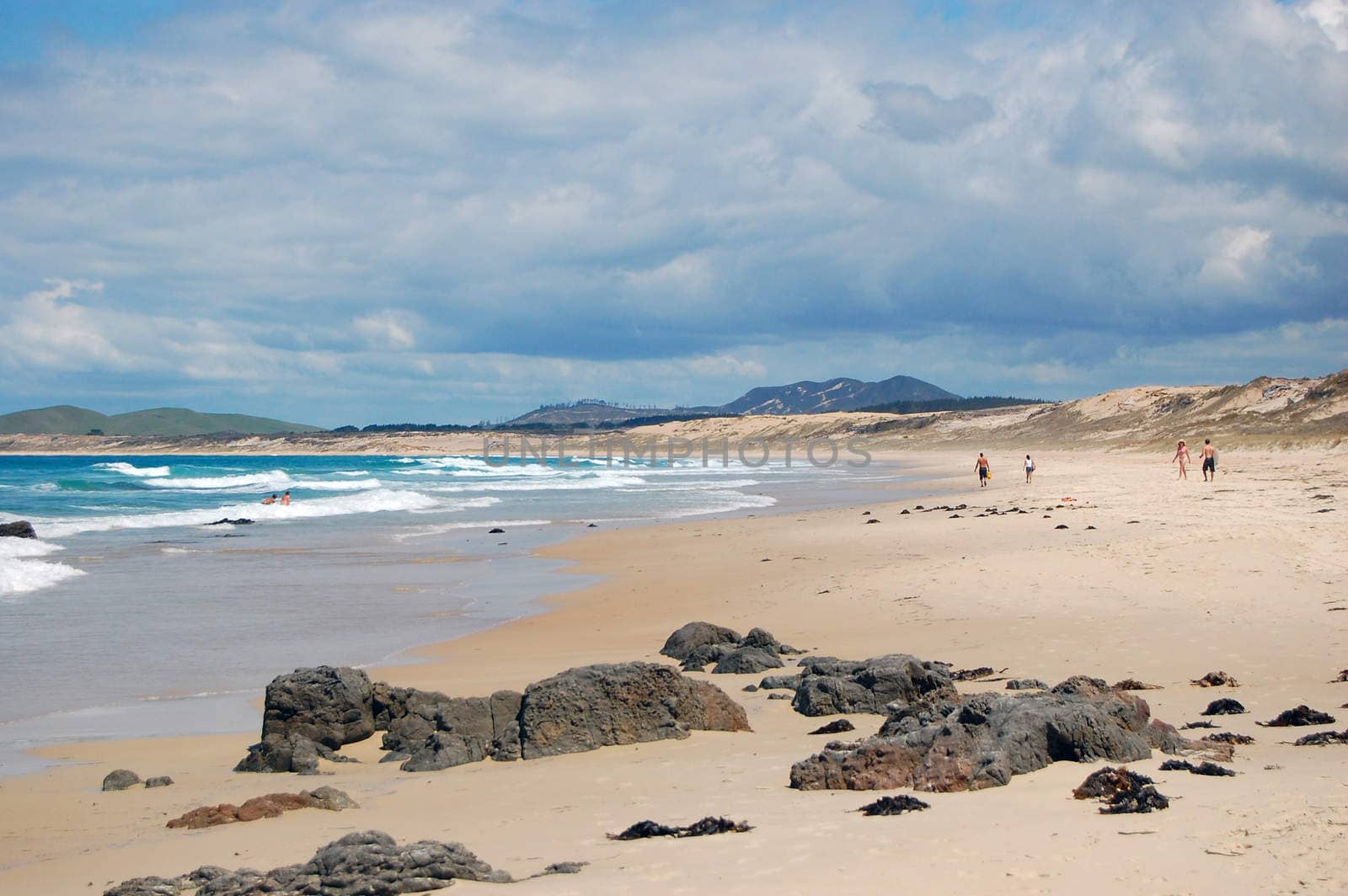 People at beach with stones, New Zealand, Northland