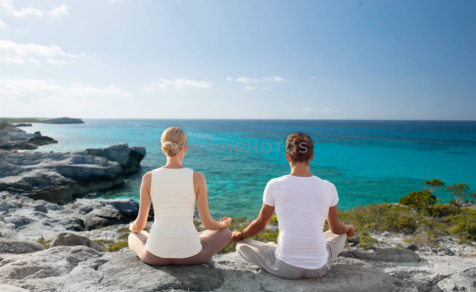 couple making yoga exercises outdoors by dolgachov