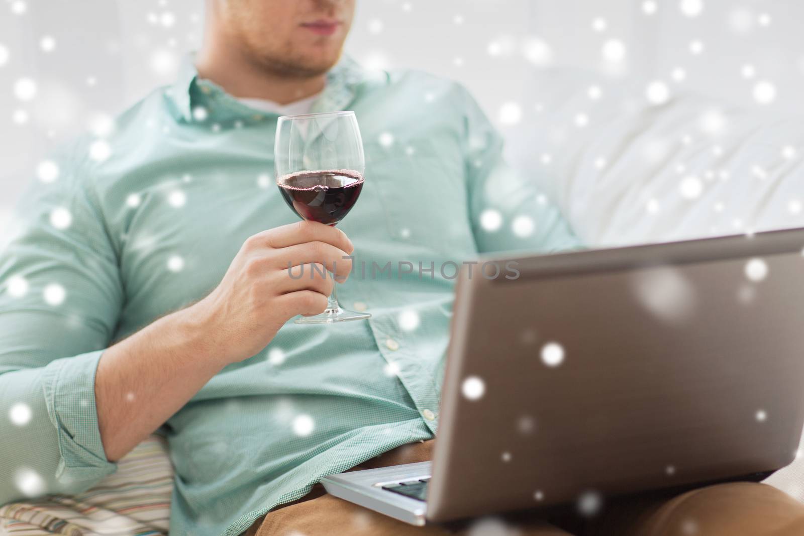 technology, drinks, leisure, home and lifestyle concept - close up of man with laptop and glass of wine at home