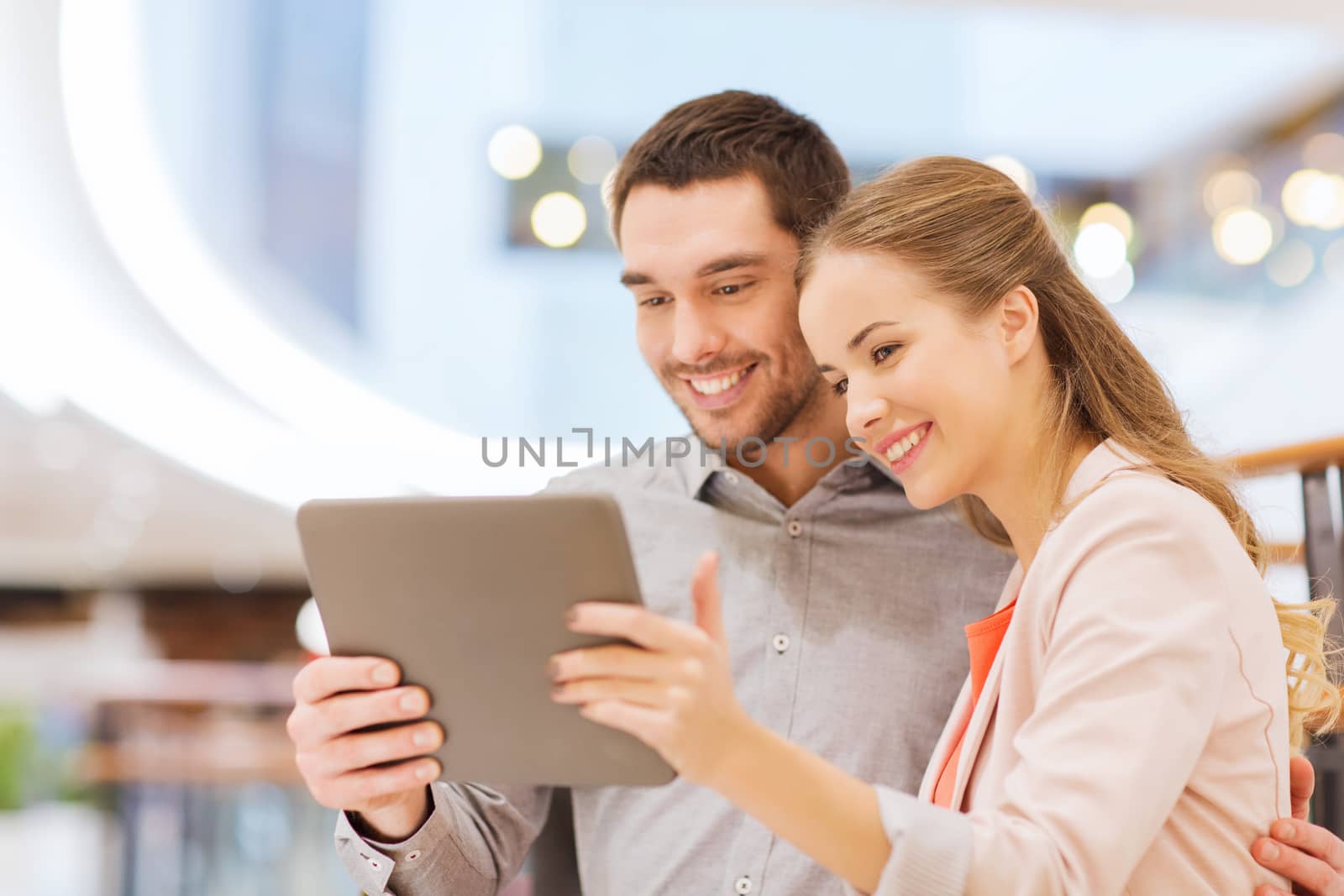 happy couple with tablet pc taking selfie in mall by dolgachov