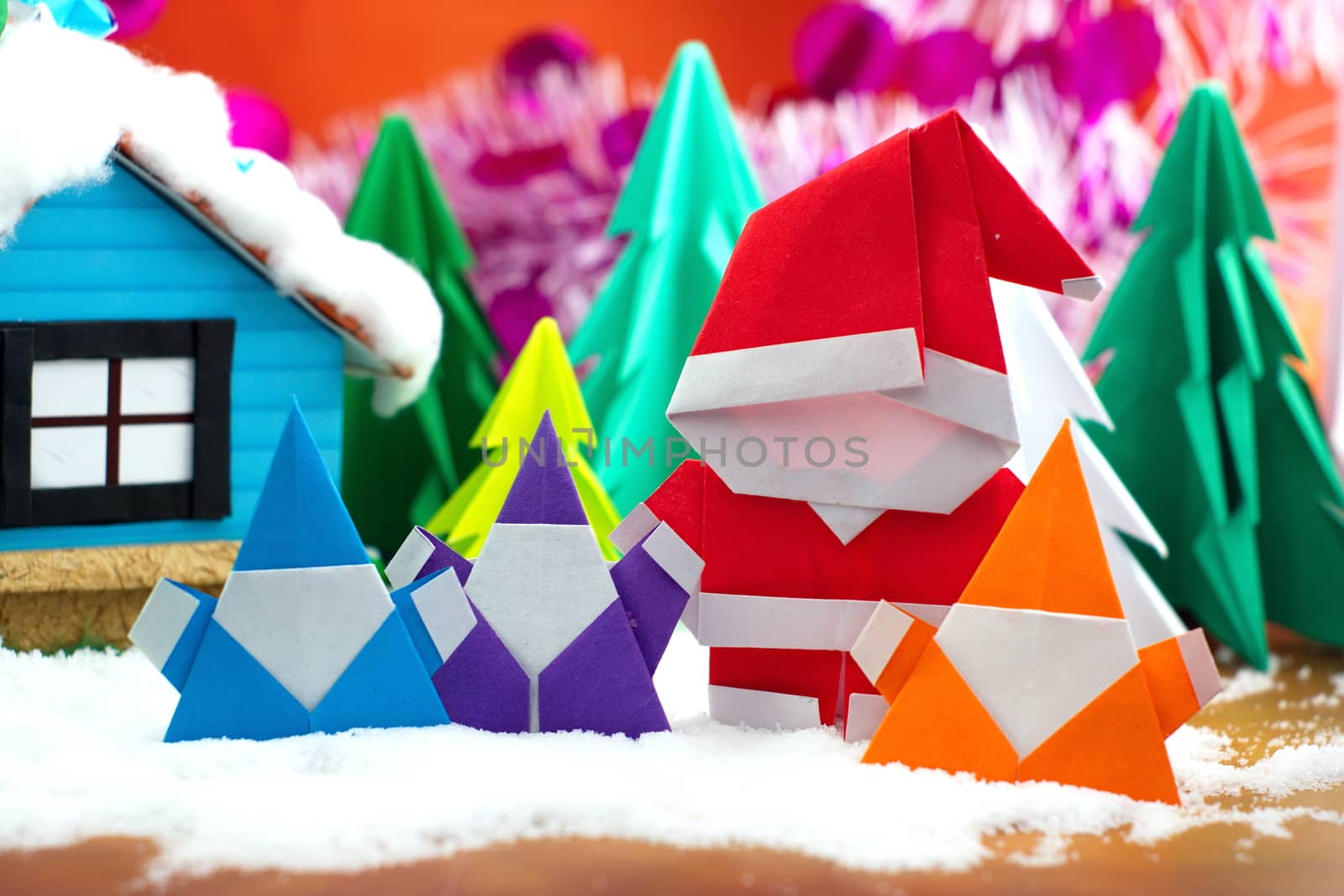 Santa claus family on snow field, small house and christmas tree background