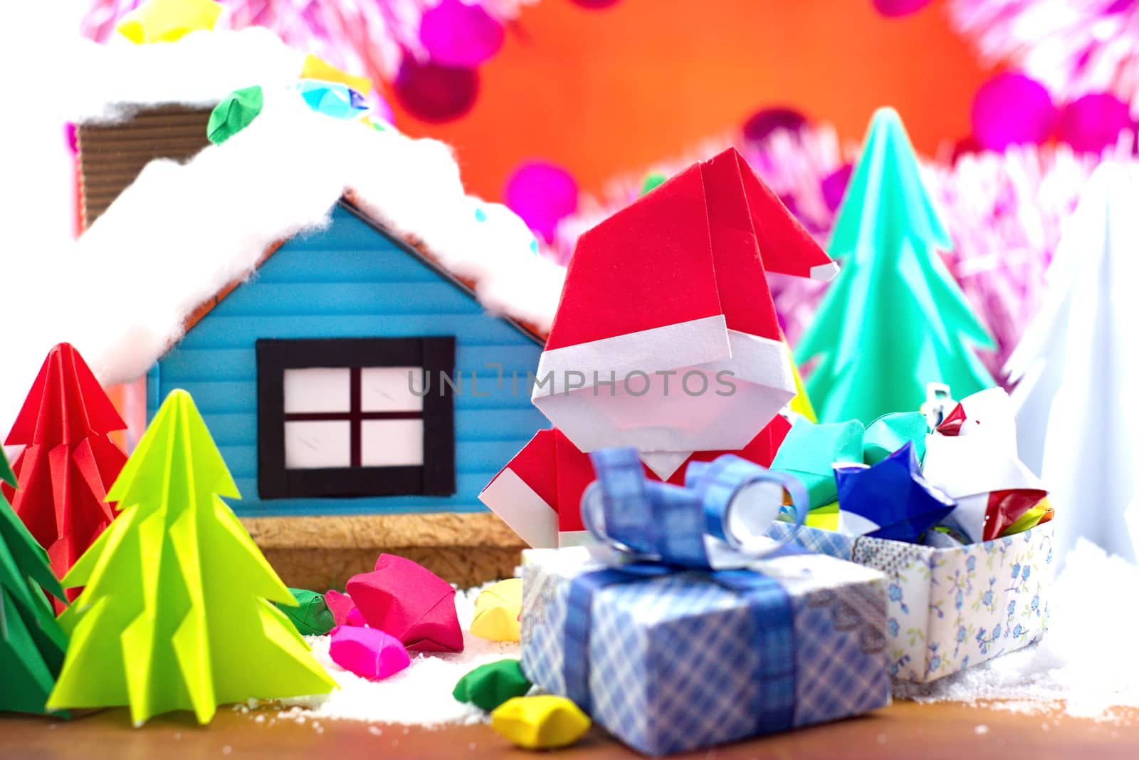 Santa Claus foled paper and small house in snow field, with christmas tree background