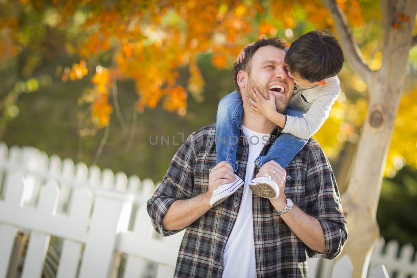 Mixed Race Boy Riding Piggyback on Shoulders of Caucasian Father by Feverpitched