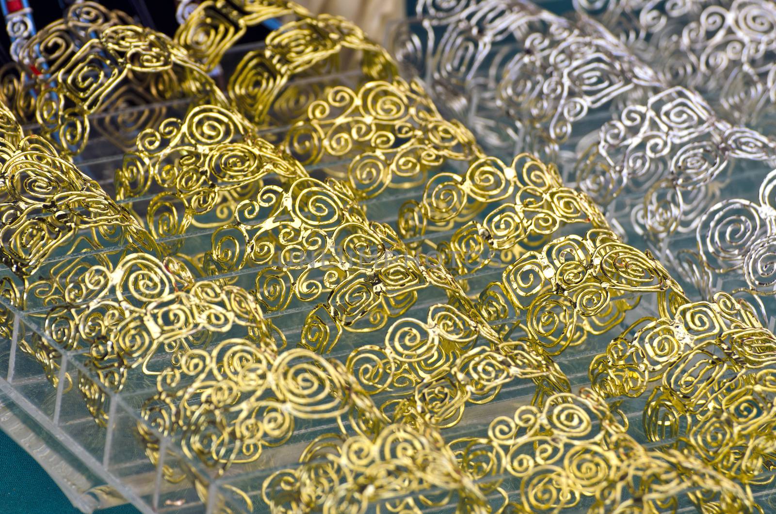 Spiraled ornaments of gold and silver jewelry in market