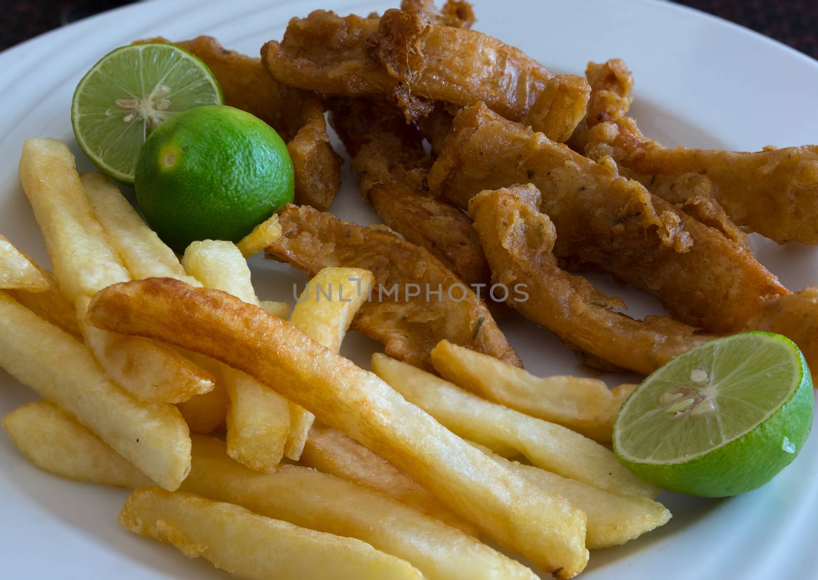 In the photo fried calamari served with fries and three lime as a garnish.