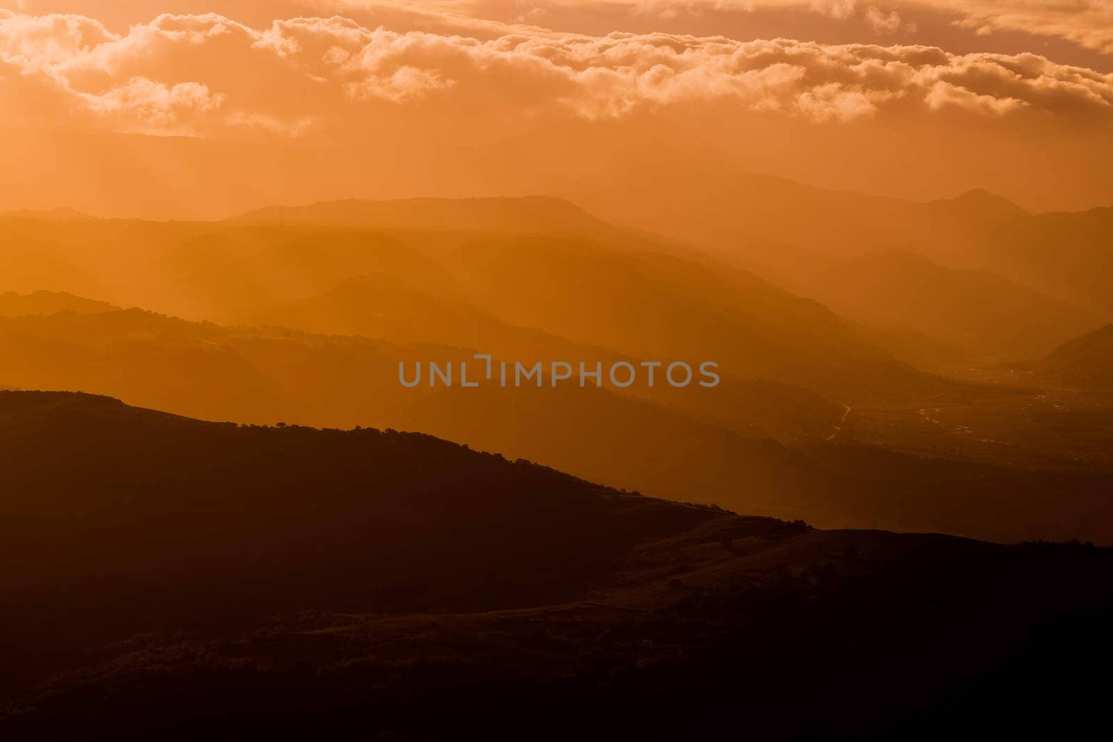 mountains silhouette at sunset with fog, natural light tint blue