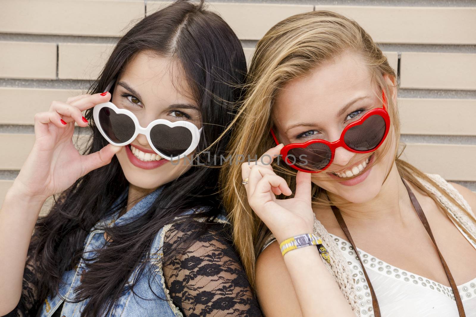 Two beautiful teenage girl wearing funny sun glasses