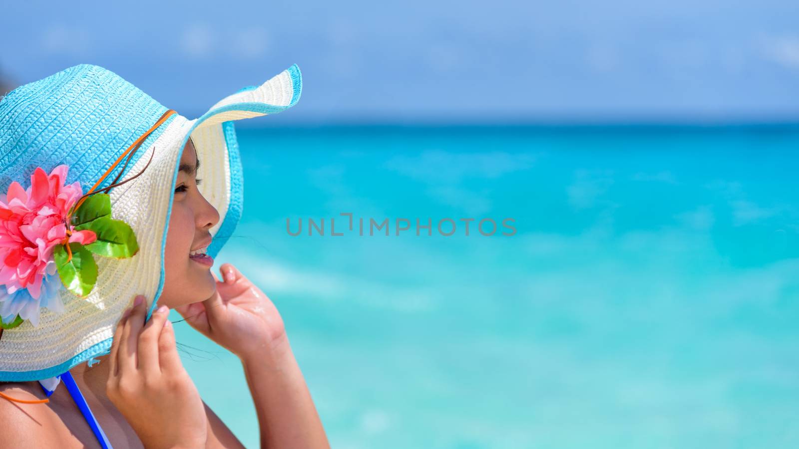 Face young woman wearing sun protection hat  is happy to see the beautiful nature of sea under the summer sky at Koh Miang Island in Mu Ko Similan National Park, Phang Nga, Thailand, 16:9 wide screen