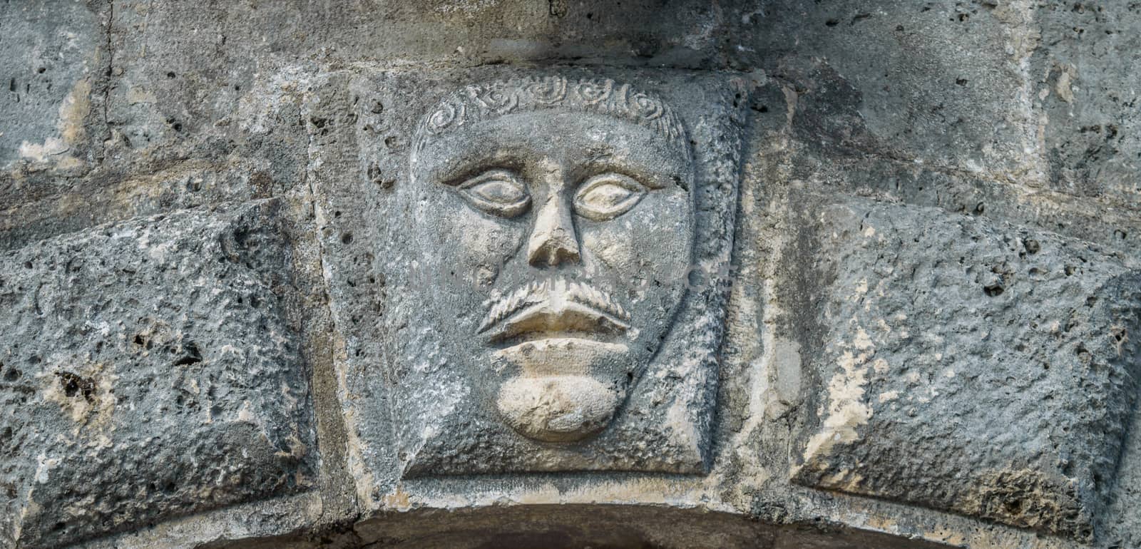 Bas-relief with man's face on musium in Perast  by radzonimo
