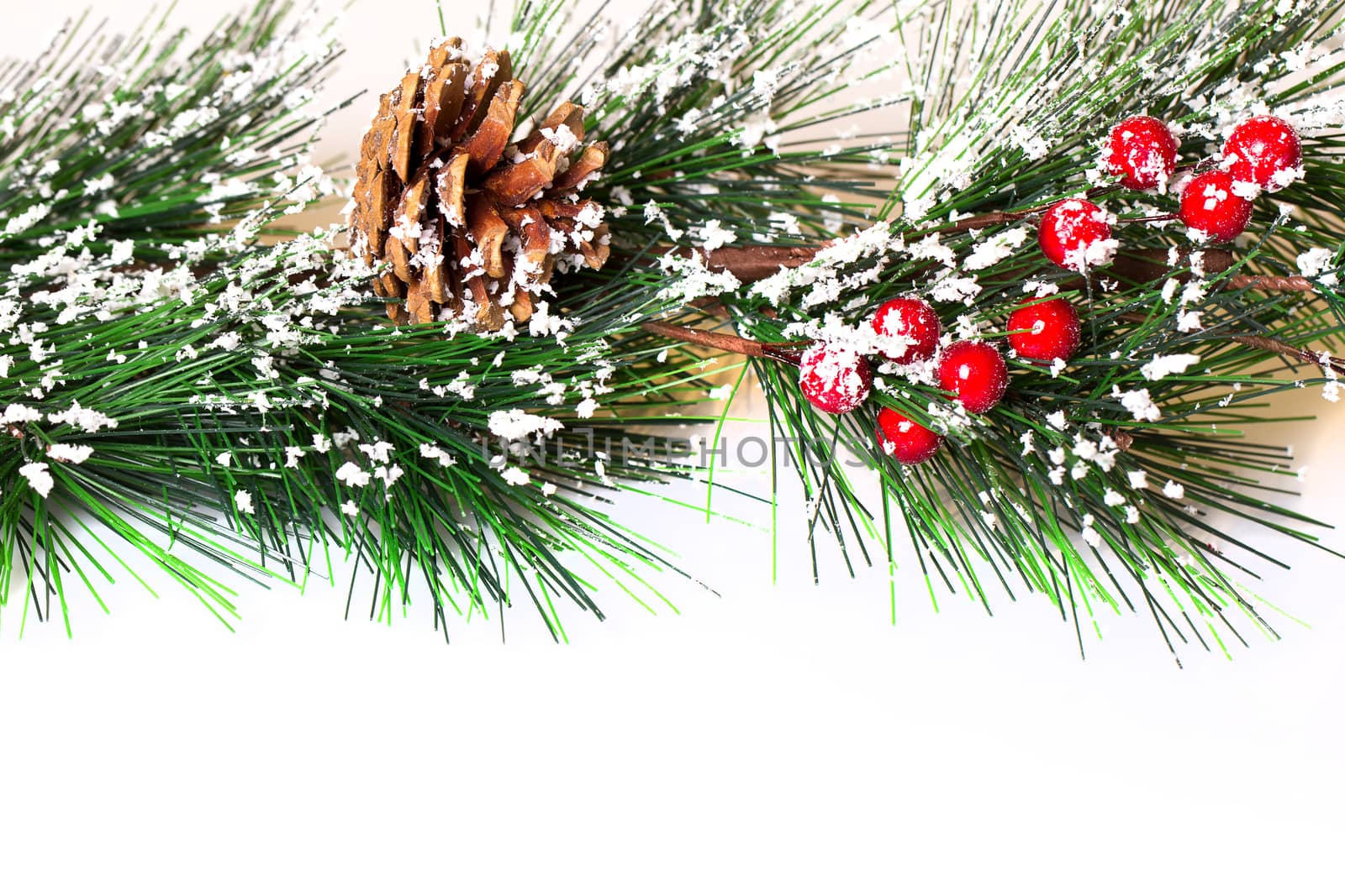 Pine branches with Christmas ornaments on white
