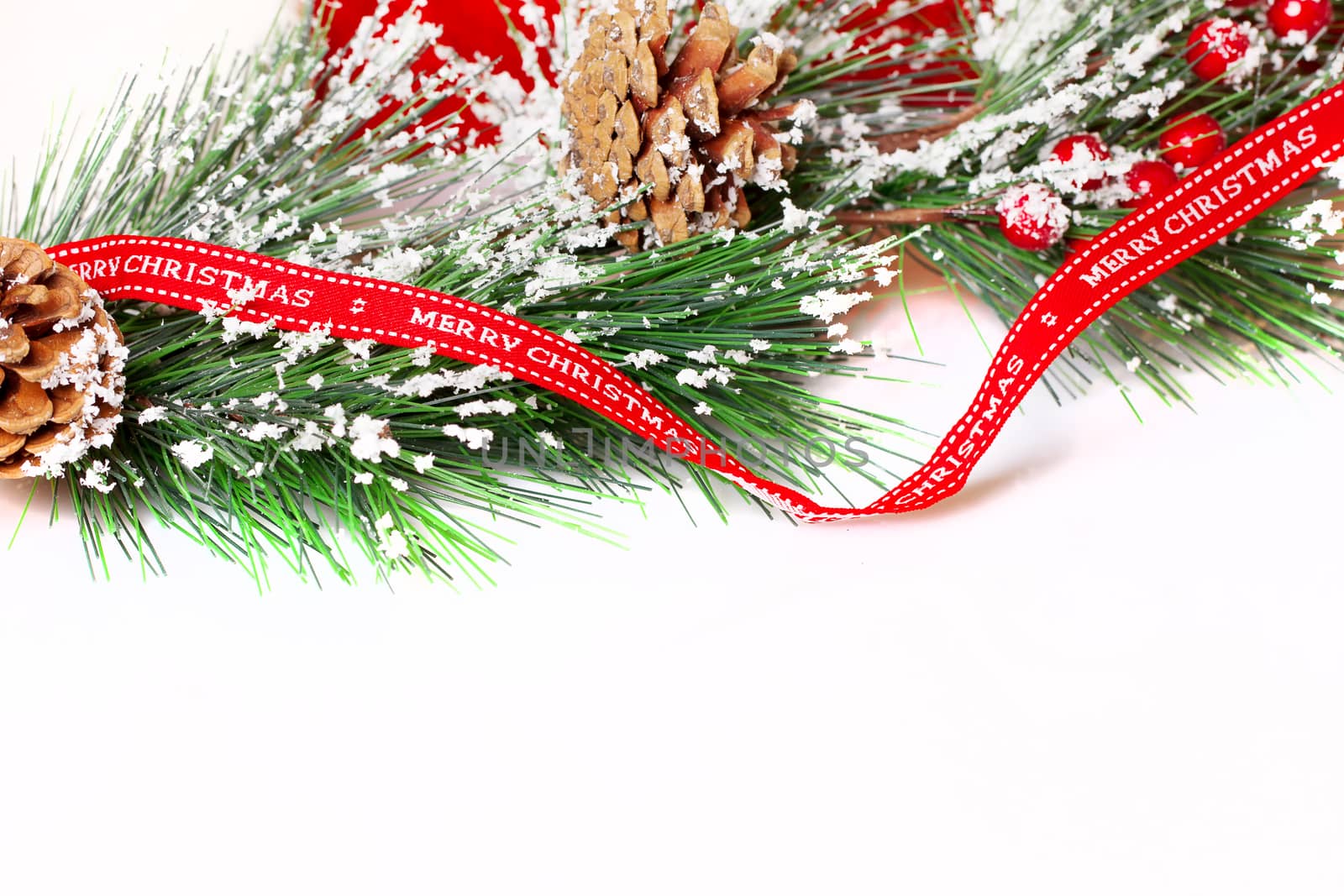 Pine branches with Christmas ornaments on white