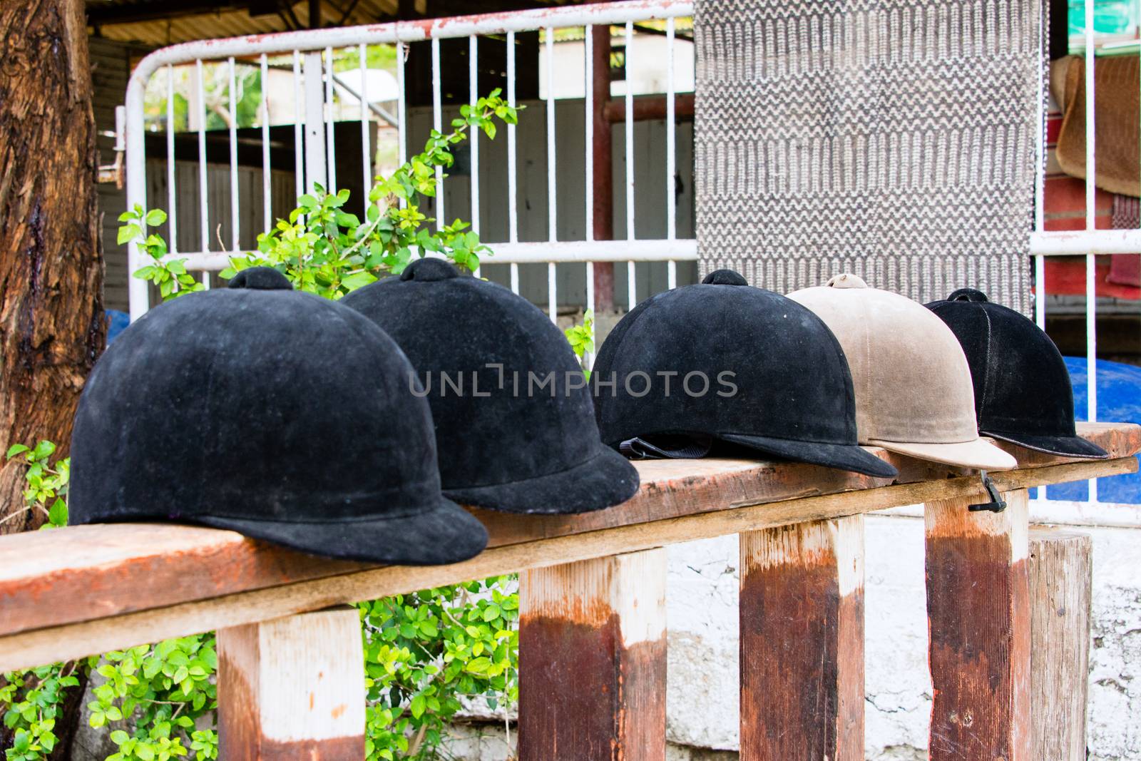 Helmets jockeys lying on a wooden stand near the site for training