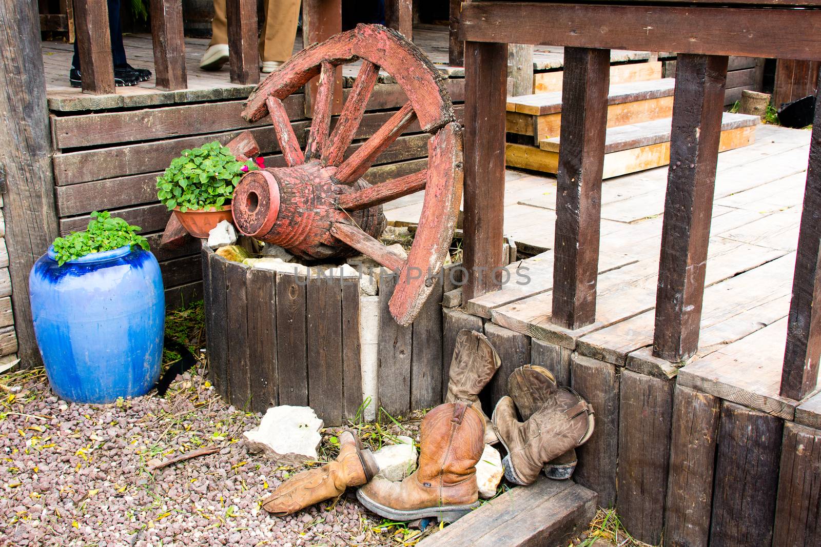 Decorative corner with a well, an old wheel and cowboy boots