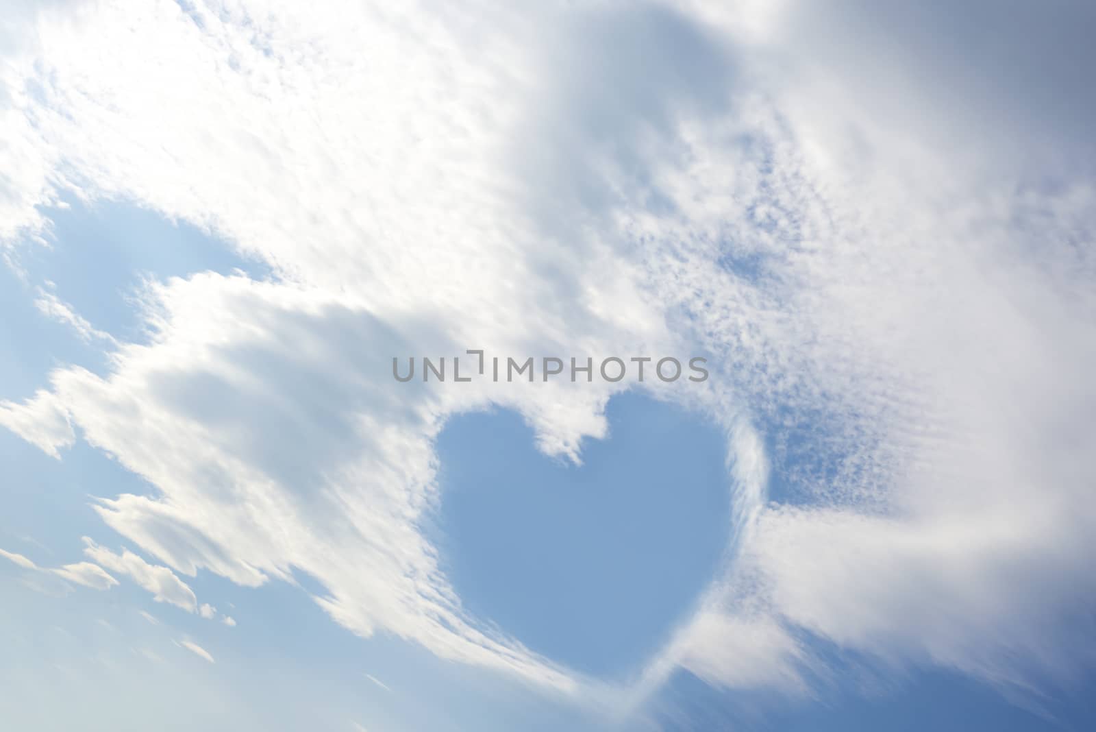 blue sky love heart among white fluffy clouds