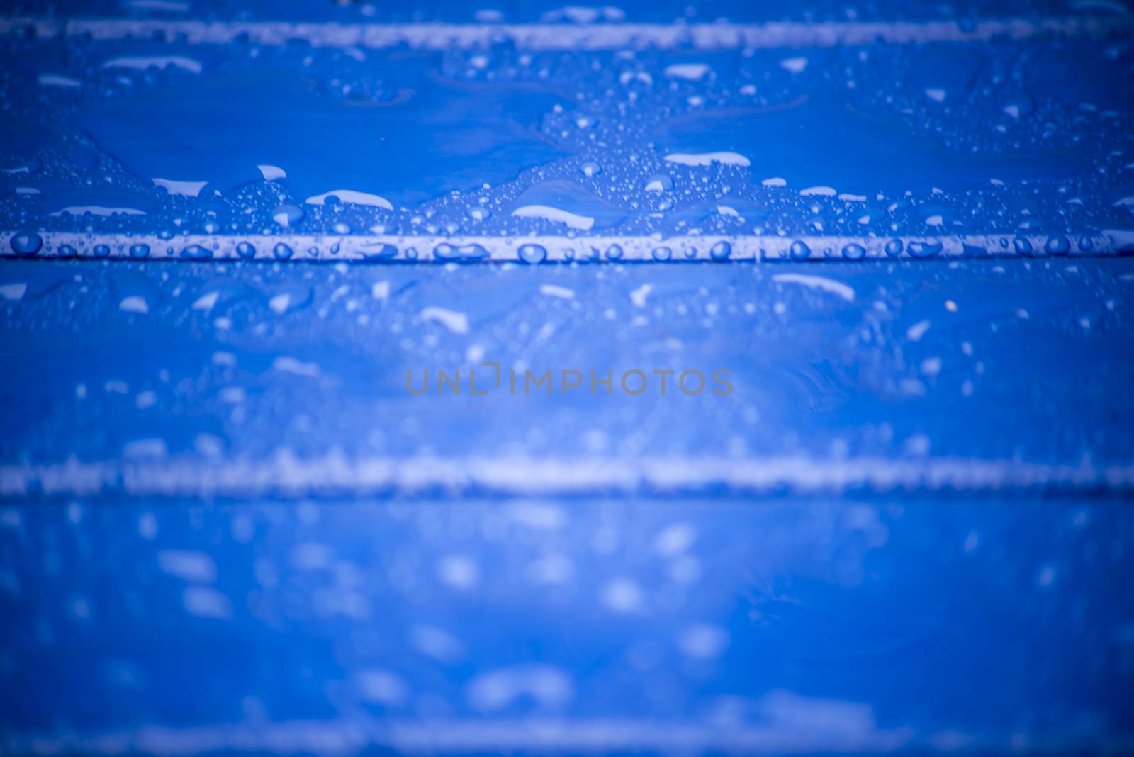 blue wooden planks with rain drops by morrbyte