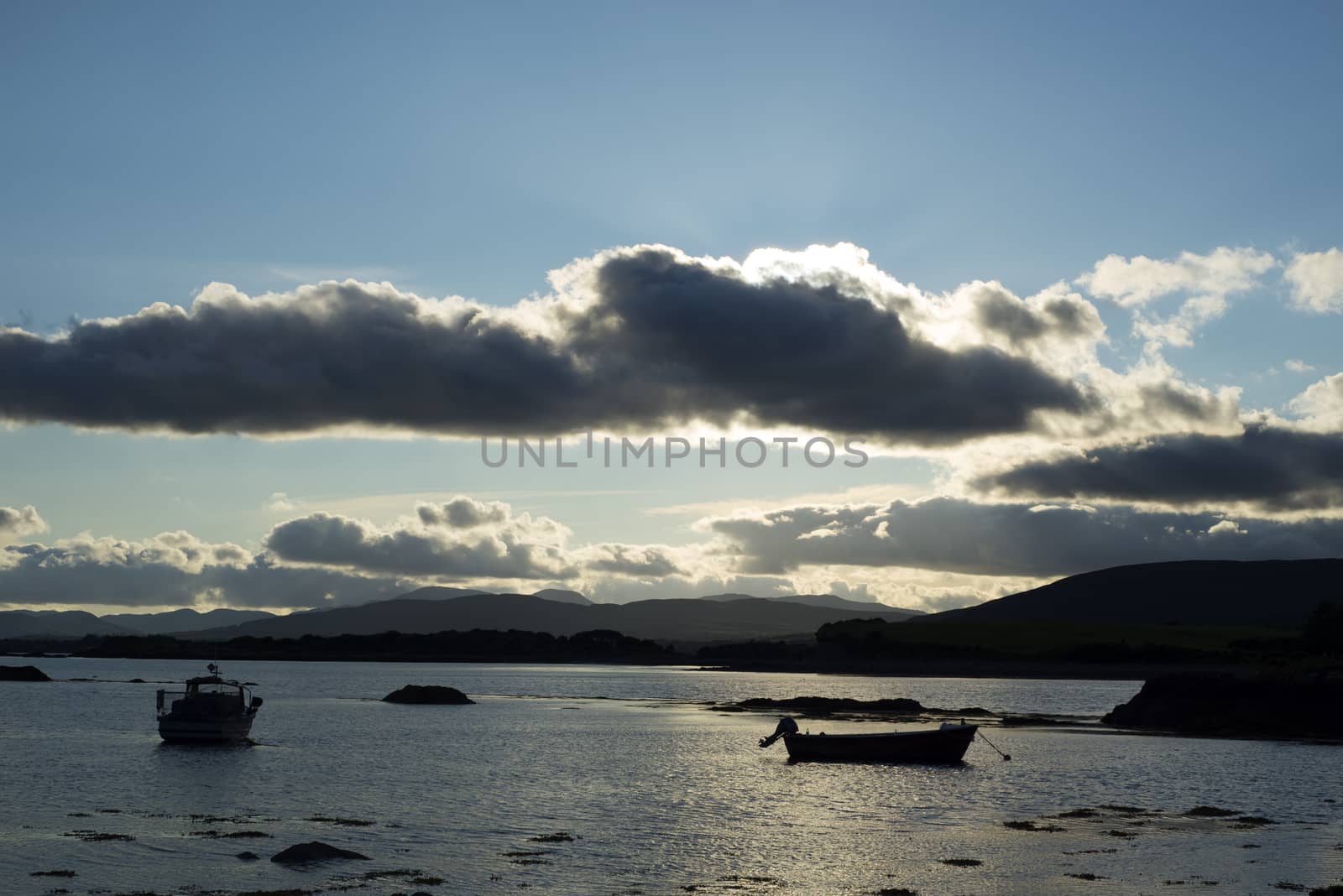 boats in a calm quiet bay at sunset by morrbyte