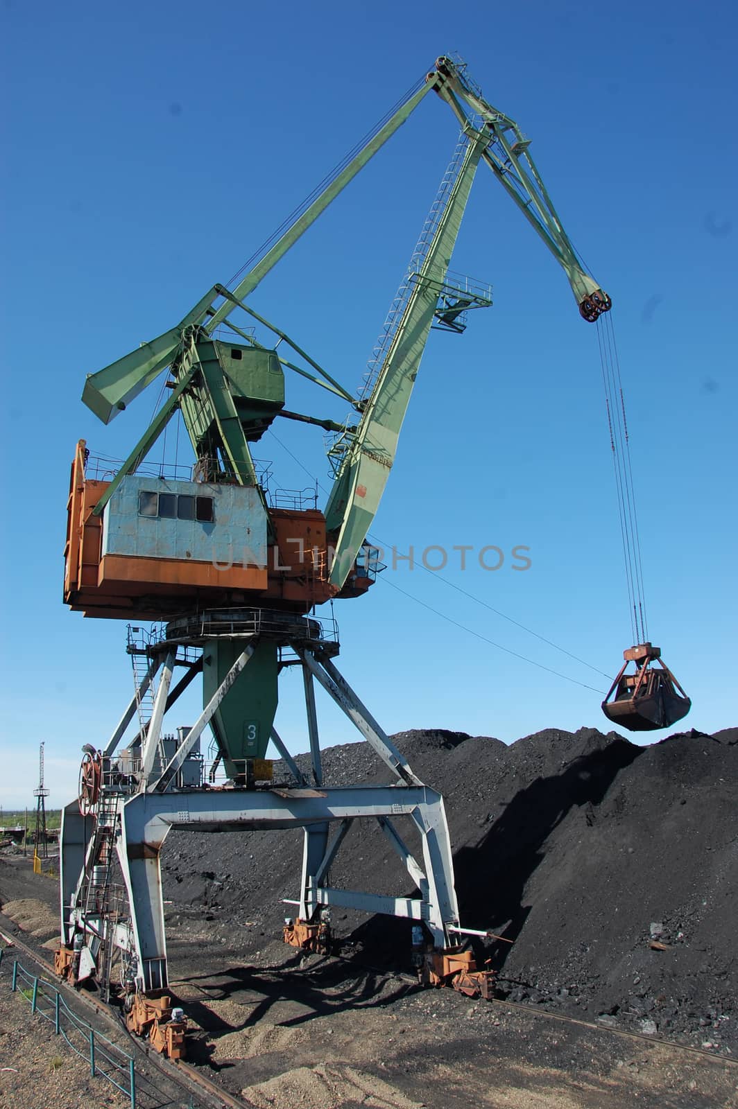 Dockside cargo crane uploads coal at Kolyma port by danemo
