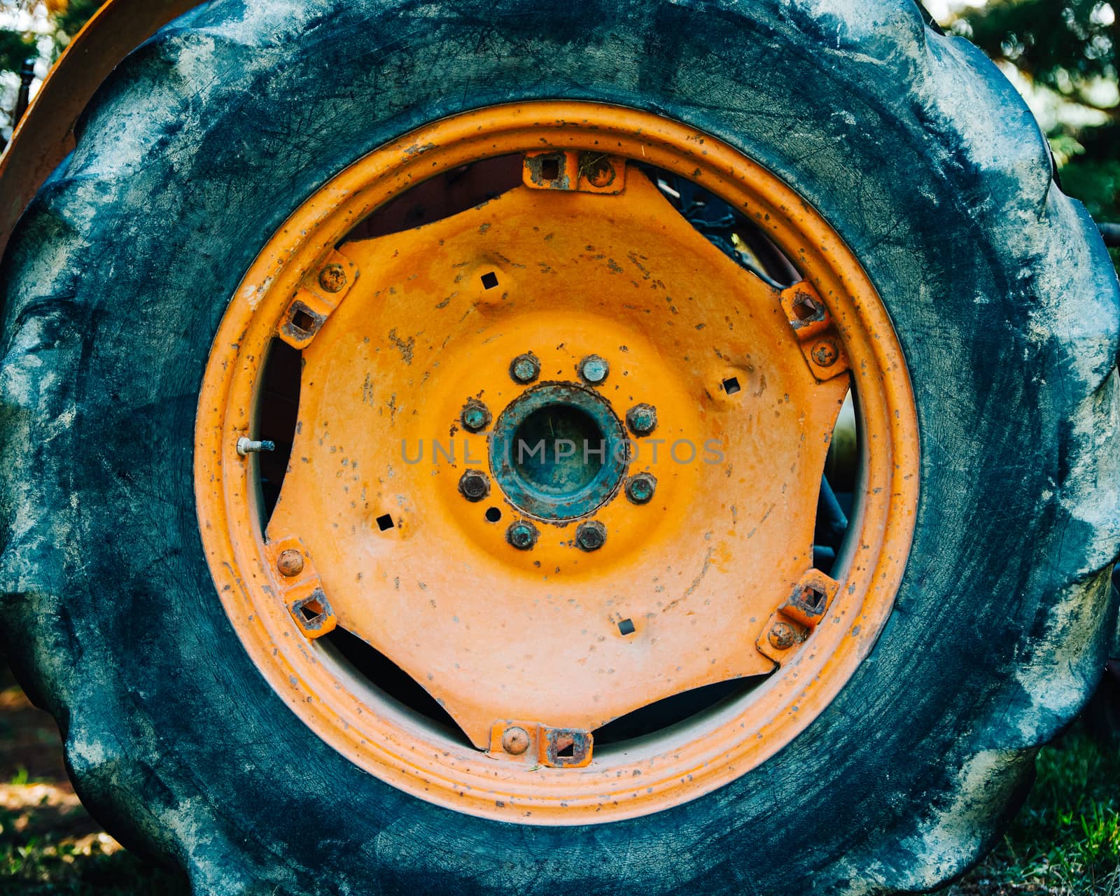Detail of an old orange tractor wheel. Film emulation and light grain filter applied.