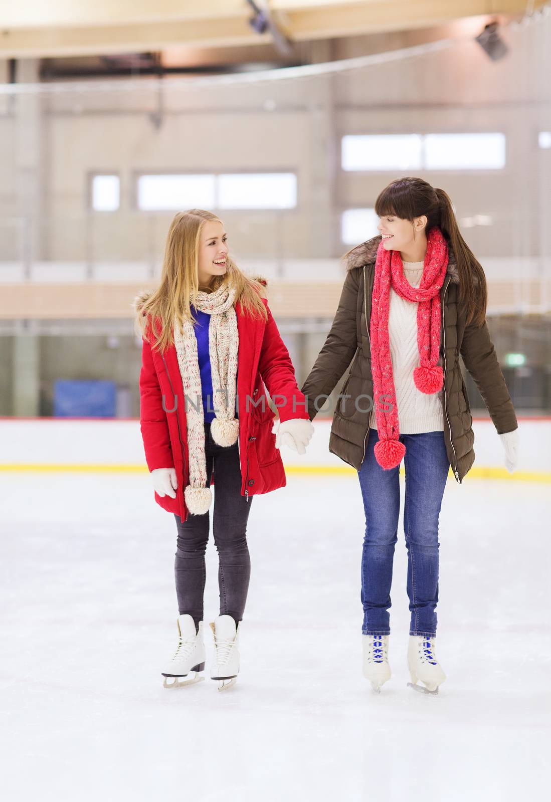 happy girls friends on skating rink by dolgachov