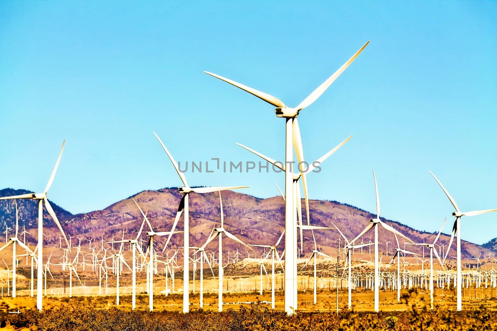 wind turbine in the middle of the desert with blue sky