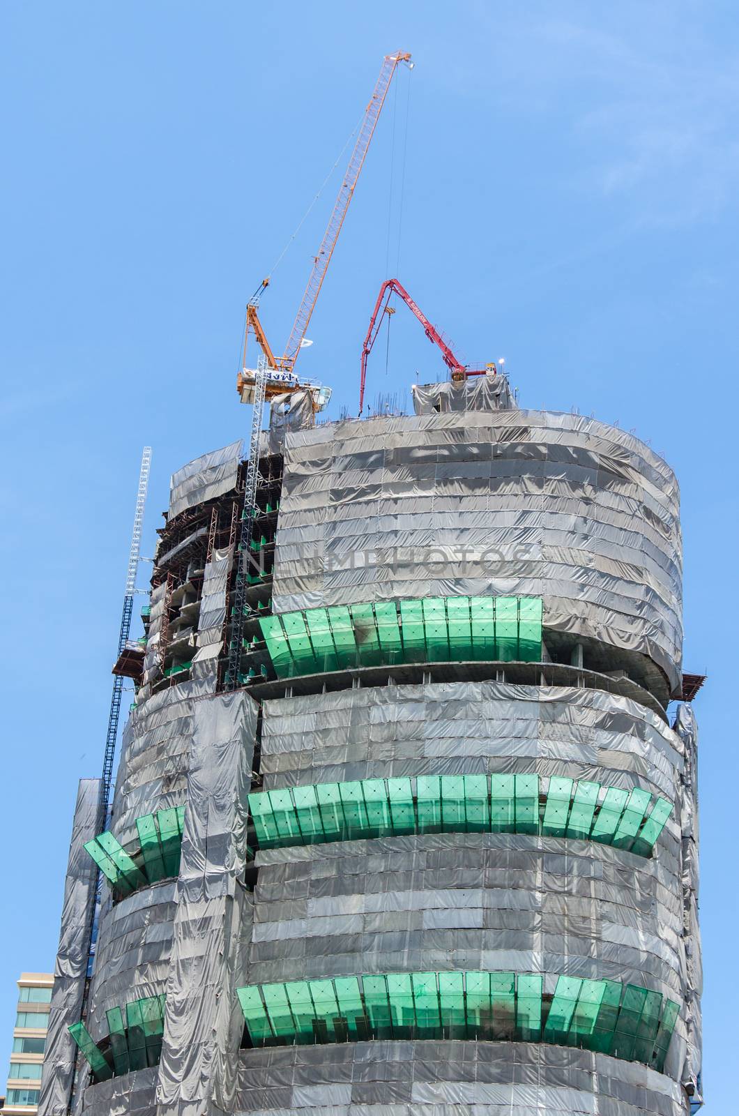 High-rise building construction using tower cranes and other construction equipment